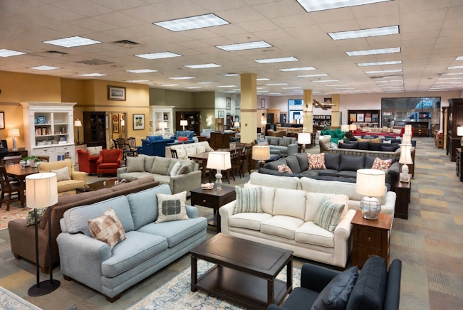 Clearance and floor model furniture showroom with sofas, dining sets, and bedroom furniture