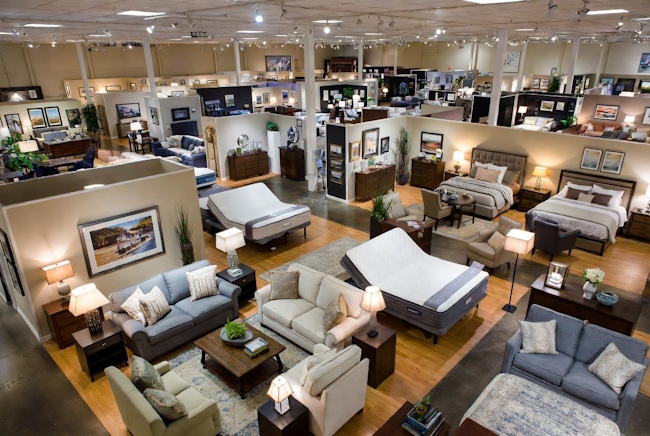 Room package showroom with living room, bedroom, dining furniture, and financing options