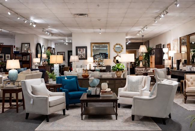 Upscale consignment furniture shop with curated chairs, rugs, lamps, and artwork